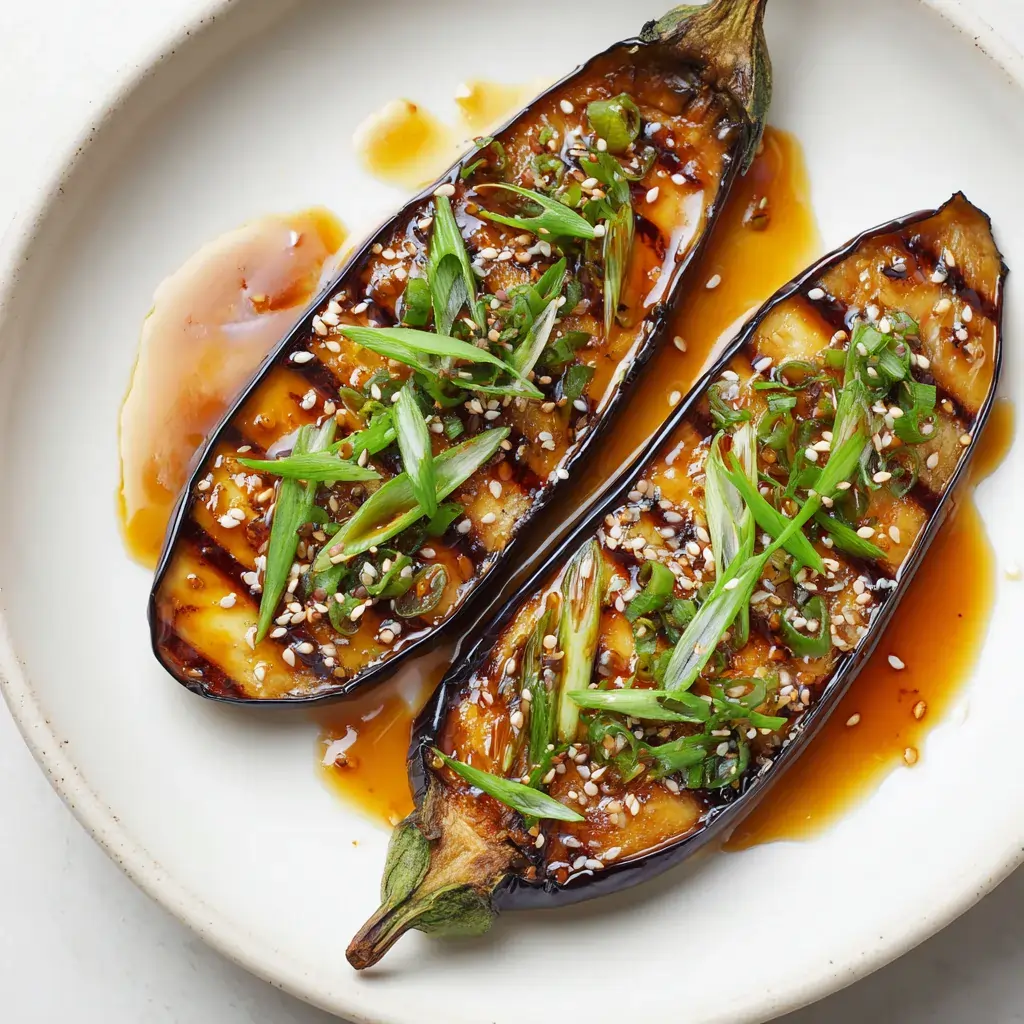 Perfectly glazed miso eggplant with caramelized surface and sesame seed garnish on white plate
