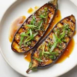 Perfectly glazed miso eggplant with caramelized surface and sesame seed garnish on white plate