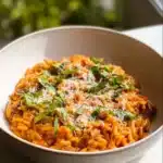 Plate of Ground Beef Orzo with Tomato Cream Sauce garnished with fresh parsley