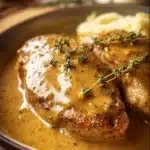 Slow cooker chicken and gravy dish served with mashed potatoes