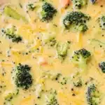 A bowl of creamy Broccoli Cheddar Soup garnished with fresh broccoli