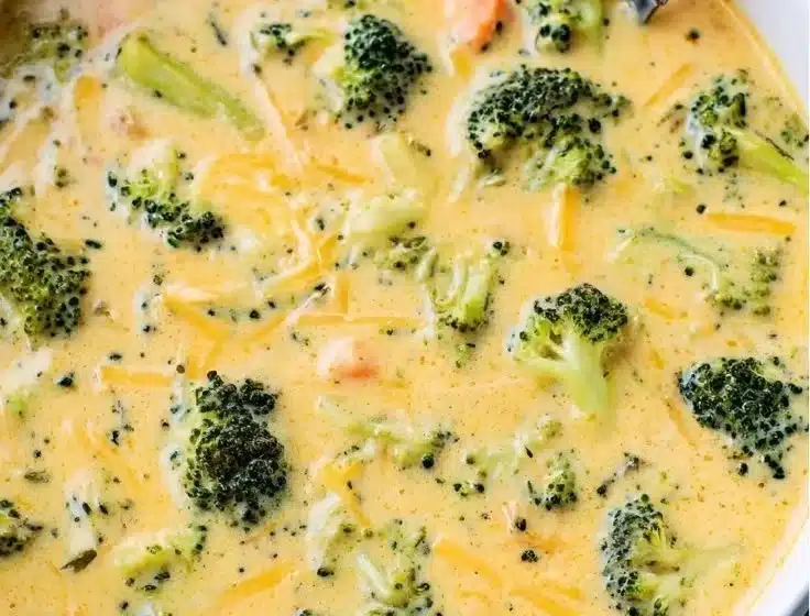 A bowl of creamy Broccoli Cheddar Soup garnished with fresh broccoli