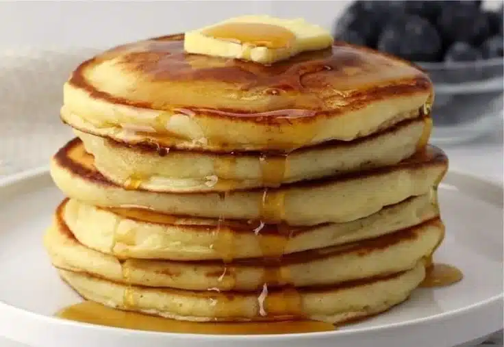 Stack of easy homemade pancakes with syrup and berries