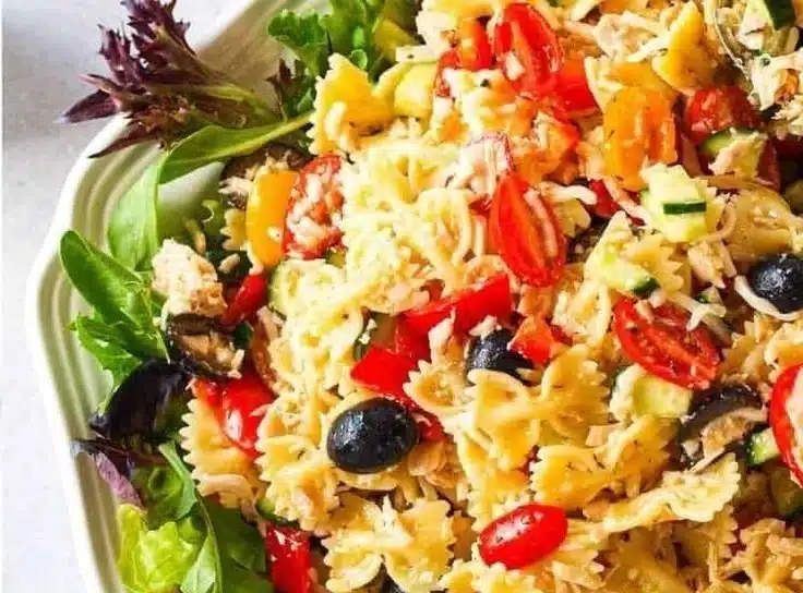 Italian tuna pasta salad with vegetables and dressing in a bowl